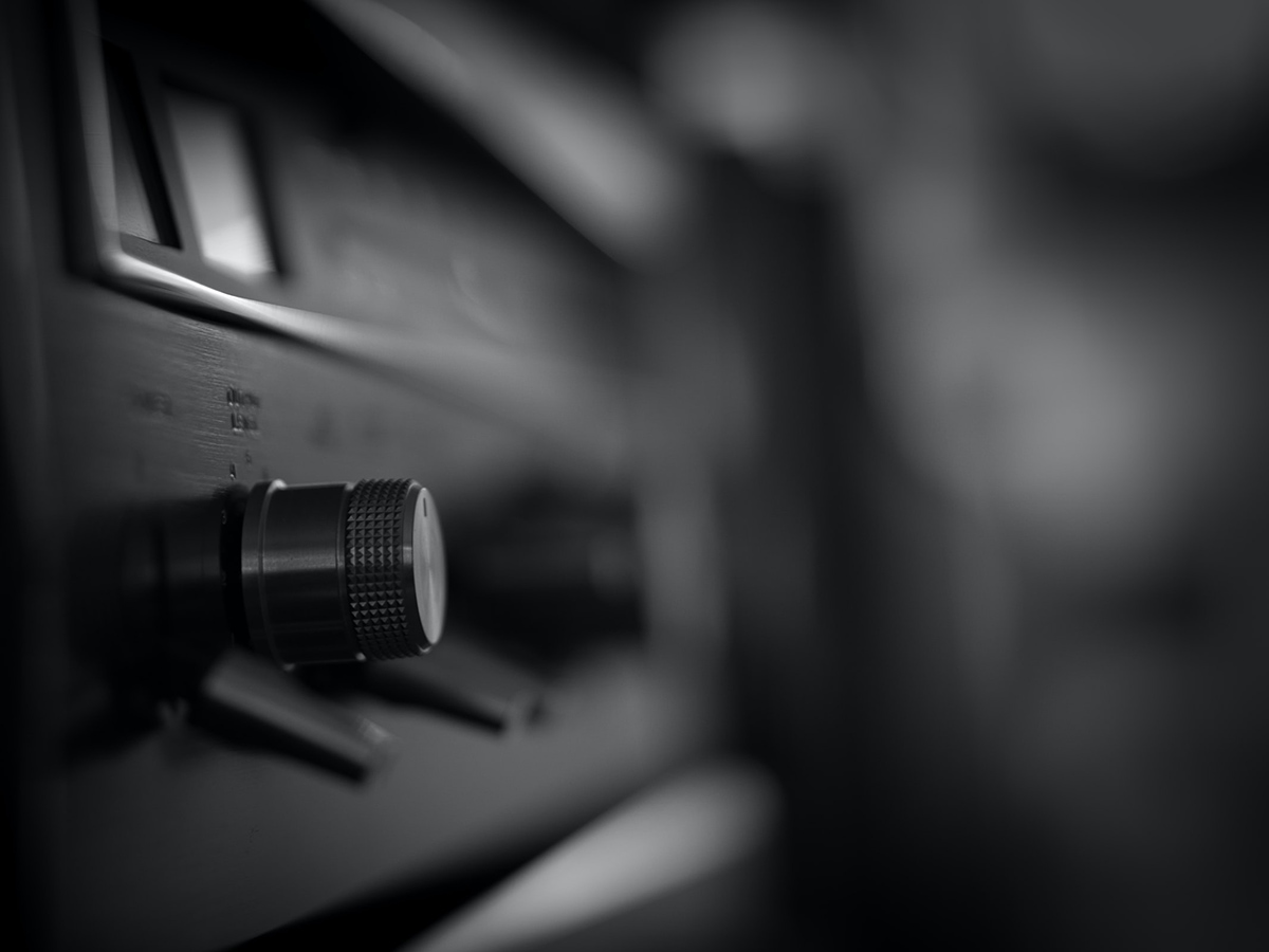 Extreme close up on metallic dial on face of retro stereo.