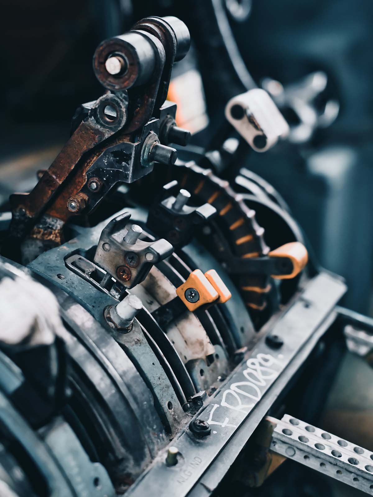 Multiple metal industrial levers within a piece of machinery.