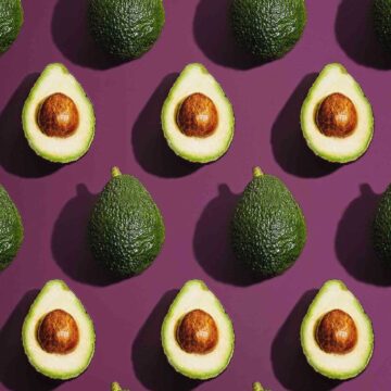 Dark purple background with rows of whole and halved avocados.